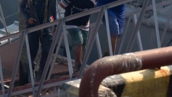 Foto de dos de los tres hombres detenidos con un fusil en el Golfo de Guayaquil, el lunes 1 de septiembre. (Televistazo)