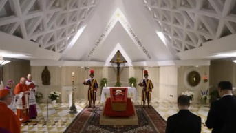 El Papa Francisco en su ataúd abierto, vestido con una túnica roja, la mitra papal en la cabeza y un rosario en la mano. (BBC)
