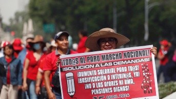 Fotografía de archivo del 15 de abril de 2024 de una integrante de la Coordinadora Nacional de Trabajadores de la Educación (CNTE) sosteniendo un cartel durante una manifestación en Ciudad de México (México). (EFE)
