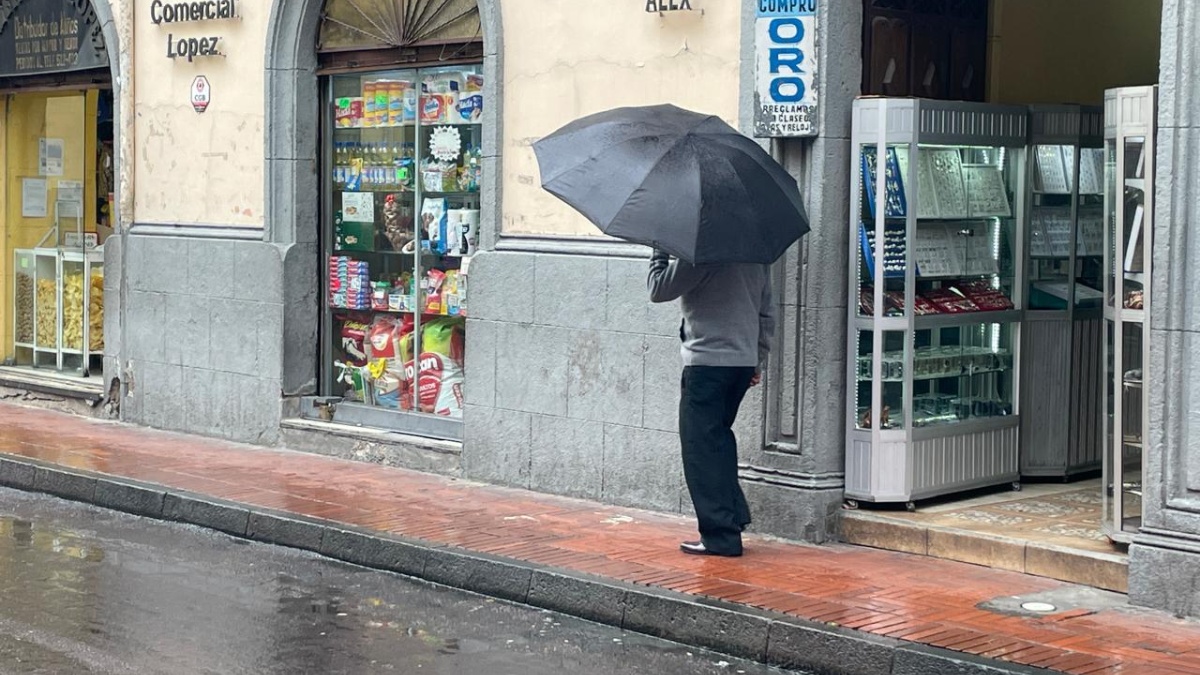 Un hombre camina con paraguas en la calle Olmedo del Centro Histórico durante la lluvia. (Diego Bravo C. / Ecuavisa)