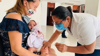 Mujer con niño en brazos a quien se le aplica una vacuna. (Foto: Internet)