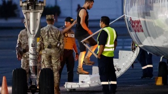 Un migrante sube a un avión para ser deportado a Colombia este martes, en el aeropuerto Marcos A. Gelabert en Ciudad de Panamá (Panamá). (EFE)