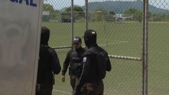 Imagen de agentes de la Policía Nacional esperando por la llegada de un helicóptero con el cadáver de un agente del GIR asesinado durante un operativo antisecuestro, este martes 13 de mayo. (Televistazo)