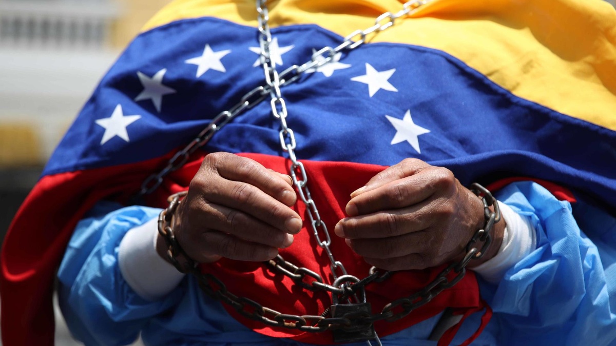 Un hombre encadenado se manifiesta afuera de la embajada de Venezuela este viernes, en Lima. (Paolo Aguilar / EFE)