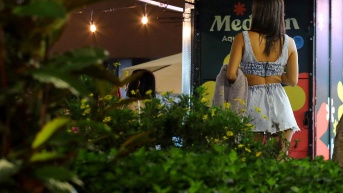 Una mujer camina por el parque Lleras de Medellín, Colombia, el 5 de junio de 2024, donde el auge del turismo ha provocado un aumento de la prostitución que arrastra a chicas menores de edad. (STR / AFP)