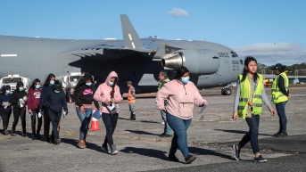 Migrantes guatemaltecos deportados caminan por la pista de la Base Aérea de Guatemala este viernes, en Ciudad de Guatemala (Guatemala). (STR / EFE)
