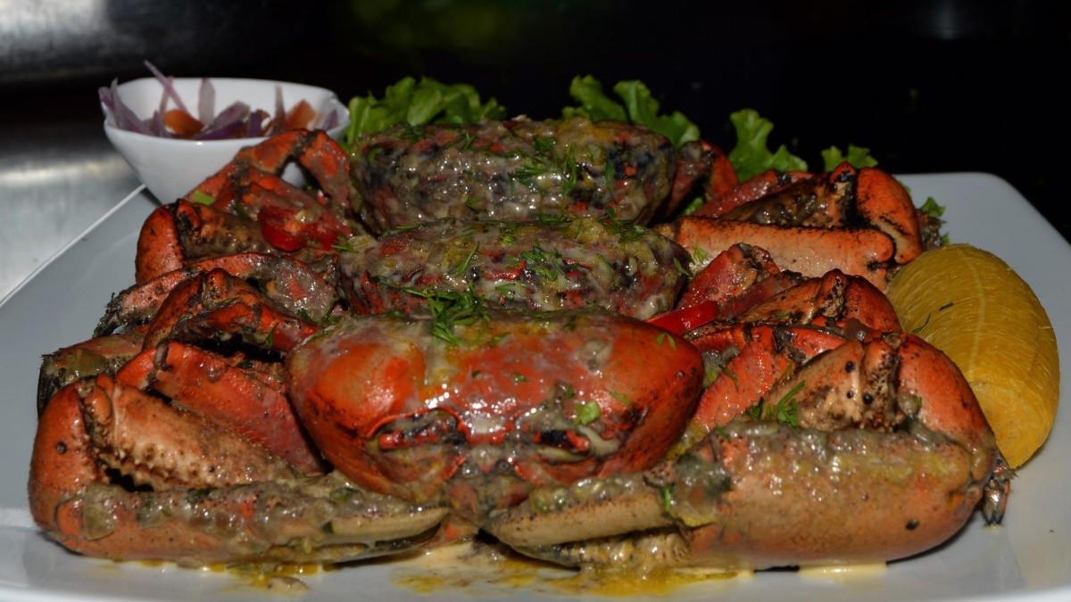 Imagen de archivo de un plato de cangrejo servido con un maduro y salsa, en el Festival de Cangrejo de Naranjal en 2023. (API)