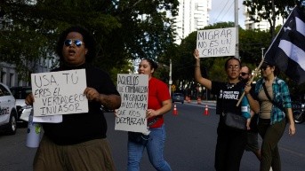 Personas sostienen carteles durante una manifestación al frente del Tribunal Federal de Hato Rey este jueves, en San Juan (Puerto Rico). (Thais Llorca / EFE)