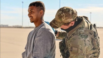 Un agente de inmigración escolta a un migrante detenido, reflejando la creciente criminalización de la migración en EE.UU. bajo las políticas actuales. (Internet)