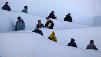 Migrantes caminan después de ser deportados de Estados Unidos en el puerto de cruce El Chaparral en Tijuana, estado de Baja California, México, el 27 de enero de 2025. (GUILLERMO ARIAS / AFP)