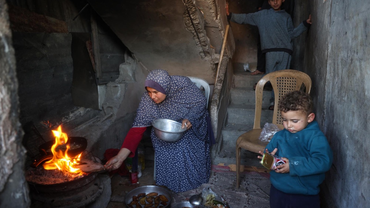 Una mujer prepara una comida para romper el ayuno (iftar) en el campo de refugiados de Bureij, en la franja central de Gaza, el 11 de marzo de 2025. (AFP)