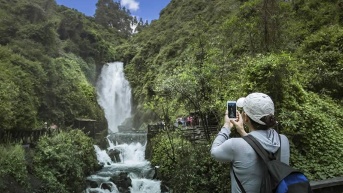 Un turista tomando fotos de la Cascada de Peguche. (Ecuavisa)