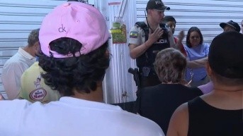 Imagen de un policia hablando con los vecinos de un barrio en el norte de Guayaquil. (Televistazo)