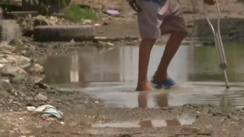 Imagen referencial de una persona caminando por un charco en Durán. Durante el invierno hubo un incremento de casos de leptospirosis. (Televistazo)