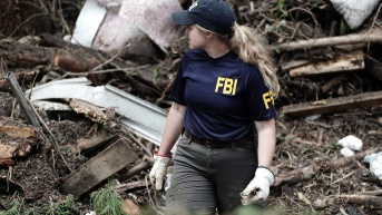 Los agentes de campo del FBI ayudan a buscar en un área, donde un perro de rescate y búsqueda K9 detectó un lugar a lo largo del río Guadalupe cerca del Blue Oak RV Park en Ingram, Texas, EE. UU. (EFE)