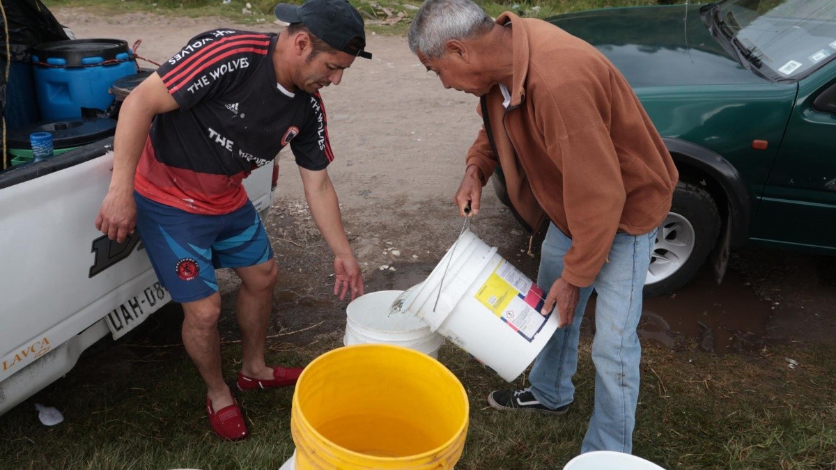 11 de julio del 2025. Moradores del sur de Quito recogen el agua en baldes. (API)