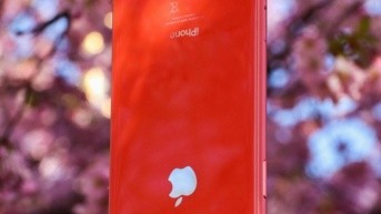 iPhone de color rojo cargándose, no de la manera más ideal. (Foto de Pexels - Tavarruk)