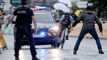 Personal de seguridad se prepara para detener a un aficionado en bicicleta antes de la meta, en la 17ª etapa del Tour de Francia, disputada el pasado miércoles, en Valence (Francia). (EFE)
