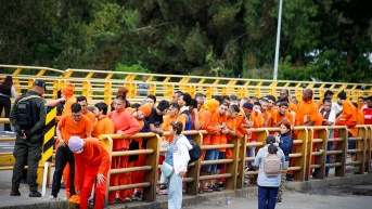 Fotografía cedida por la Cancillería de Colombia que muestra a un grupo de colombianos deportados desde Ecuador este sábado, sobre el puente internacional de Rumichaca en Ipiales (Colombia). (Cancillería de Colombia / EFE)