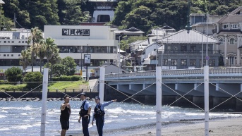 Oficiales de Policía piden a un hombre evacuar una playa vacía en Fujisawa, Japón, por el riesgo de tsunami. (YUICHI YAMAZAKI / AFP)