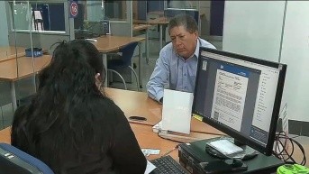 Una funcionaria del Sercop atendiendo a un usuario. (Captura de pantalla / Ecuavisa)