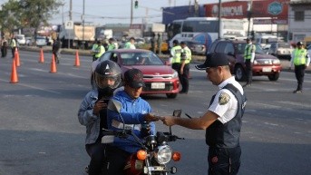 Agente de tránsito solicita documentos al conductor de una motocicleta en Durán. (API)