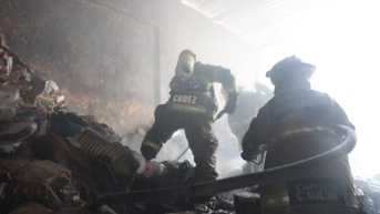 Imagen de bomberos apagando un incendio en el interior de una bodega del sur de Guayaquil, este 11 de septiembre. (Cuerpo de Bomberos de Guayaquil)