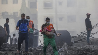 Imagen de archivo de un palestino que carga a una niña herida tras recuperarla de los escombros de una zona destruida tras los ataques aéreos israelíes en la ciudad de Gaza. (Foto de EFE)
