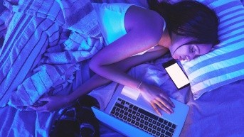 Mujer se queda dormida con el celular y la computadora. (Freepik)