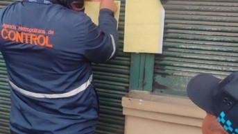 Momento en que los técnicoa de la AMC clausuran el local en Chillogallo. (Cortesía de la AMC)