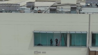 Imagen de personal poniendo nuevos vidrios tras el ataque armado en el Hospital Monte Sinaí. (Televistazo)