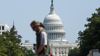 Foto de archivo que muestra a un transeúnte cruzando la avenida Pensilvania frente al Capitolio de los Estados Unidos, en Washington D. C. (EFE)