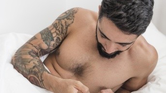 Hombre viendo el celular en una cama. (Freepik)