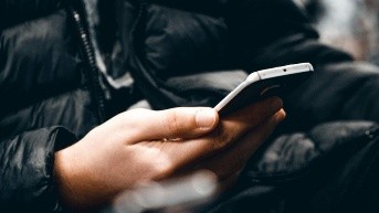 Hombre usando su teléfono celular (Mert Kahveci [Unsplash])