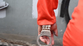 Imagen de un preso caminando con una esposa solo puesta en una mano. Foto tomada en Honduras. (AFP/Orlando Sierra)