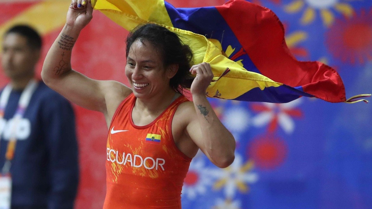 La ganadora de la medalla de oro, Luisa Valverde, de Ecuador, celebra con una bandera de su país tras ganar en lucha libre de 57 Kg de los vigésimos Juegos Bolivarianos este lunes, en Lima (Perú). (EFE)