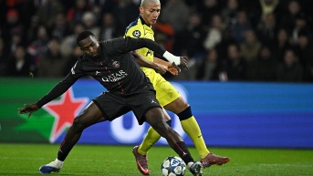 El defensa ecuatoriano del Paris Saint-Germain, Willian Pacho (izquierda), disputa el balón con el delantero brasileño del Tottenham, Richarlison, durante la quinta jornada de la fase inicial de la Champions League (AFP)