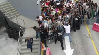 Captura de pantalla del instante en el que una multitud tumbó la reja de un supermercado de Guayaquil. (Televistazo)