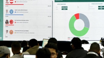 Pantallas que muestran los resultados parciales de las elecciones presidenciales en Tegucigalpa. (EFE)