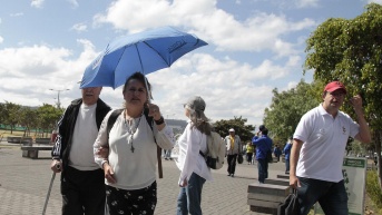 Foto de archivo, ciudadanos se protegen del fuerte sol en Quito. (API)