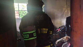 Un efectivo del CBQ interviene en la vivienda donde ocurrió el incendio, en Puembo. (Cortesía del CBQ)