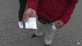 Un ciudadano muestra su turno para recibir un servicio en la ANT (Ecuavisa)