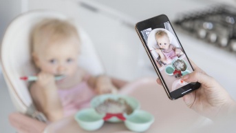 Close-up madre tomando foto del bebé (Freepik)