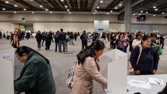 Votantes ecuatorianos preparan sus papeletas en el centro de votación instalado en el centro de convenciones IFEMA de Madrid. (EFE - Archivo)