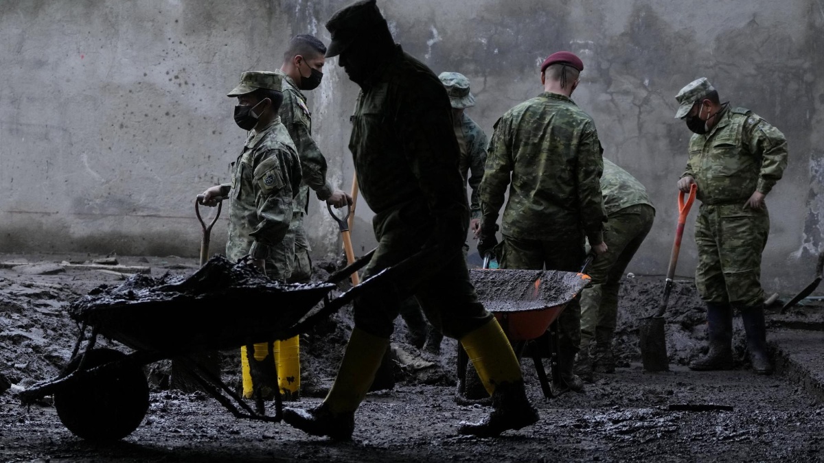 Soldados retiran escombros y lodo de una casa después del derrumbe de una ladera debilitada por la lluvia, arrasando casas y un campo deportivo en Quito, Ecuador, el jueves 3 de febrero de 2022. (AP Foto/Dolores Ochoa)