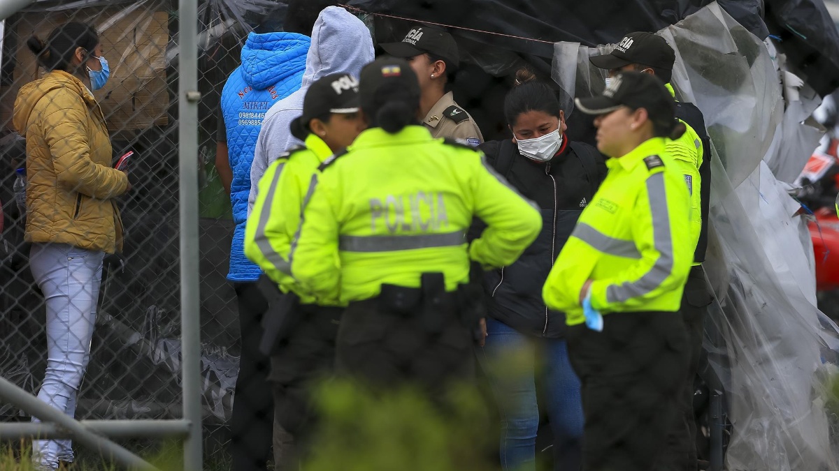 Familiares de reos hablan con autoridades para recibir información, en los exteriores de la cárcel de Cotopaxi. (EFE)