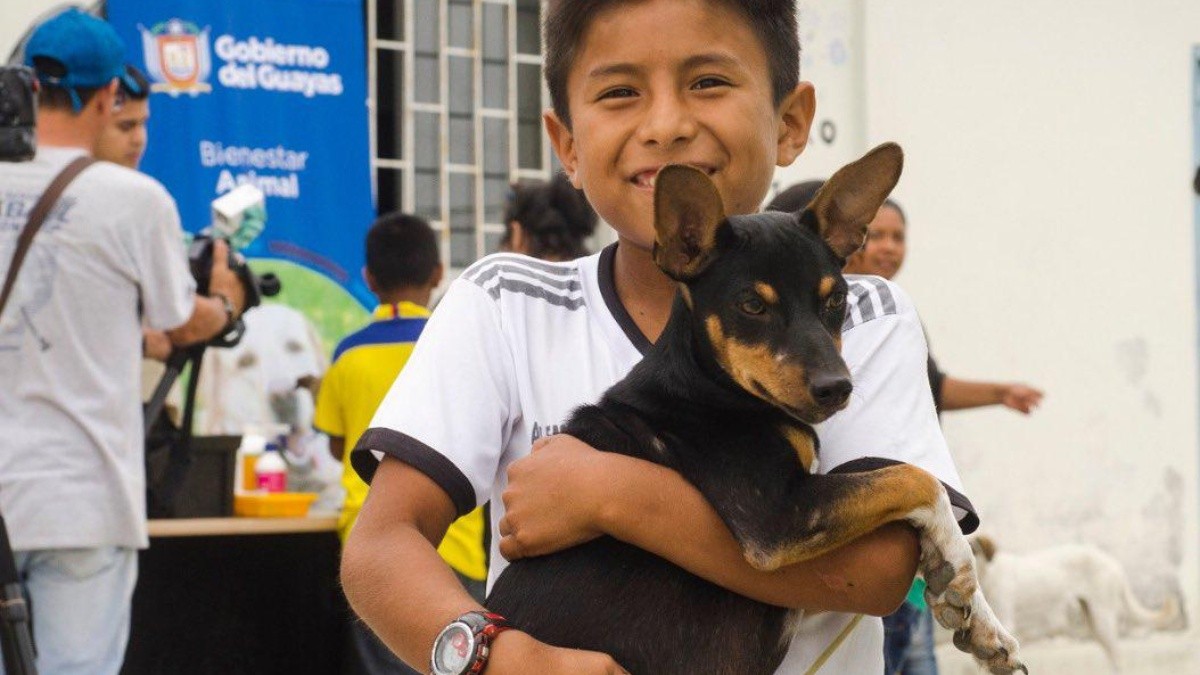 Imagen de un niño sosteniendo a su mascota. (Prefectura del Guayas)