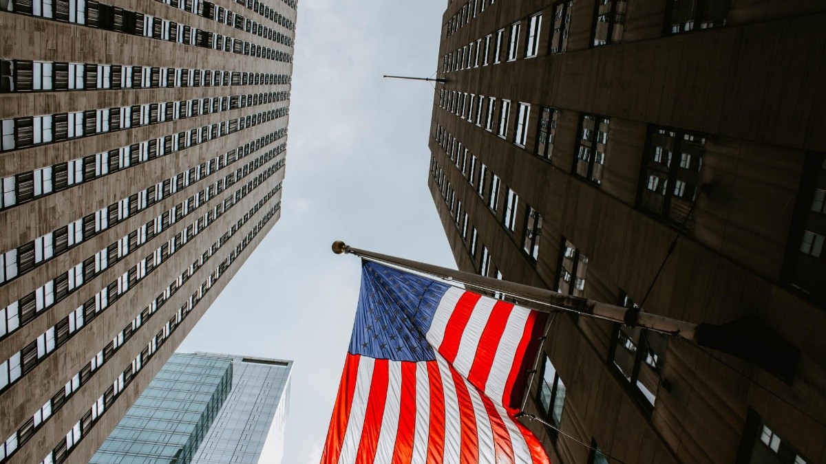 Bandera estadounidense ondeando en un edificio de Manhattan, NY (Freepick)