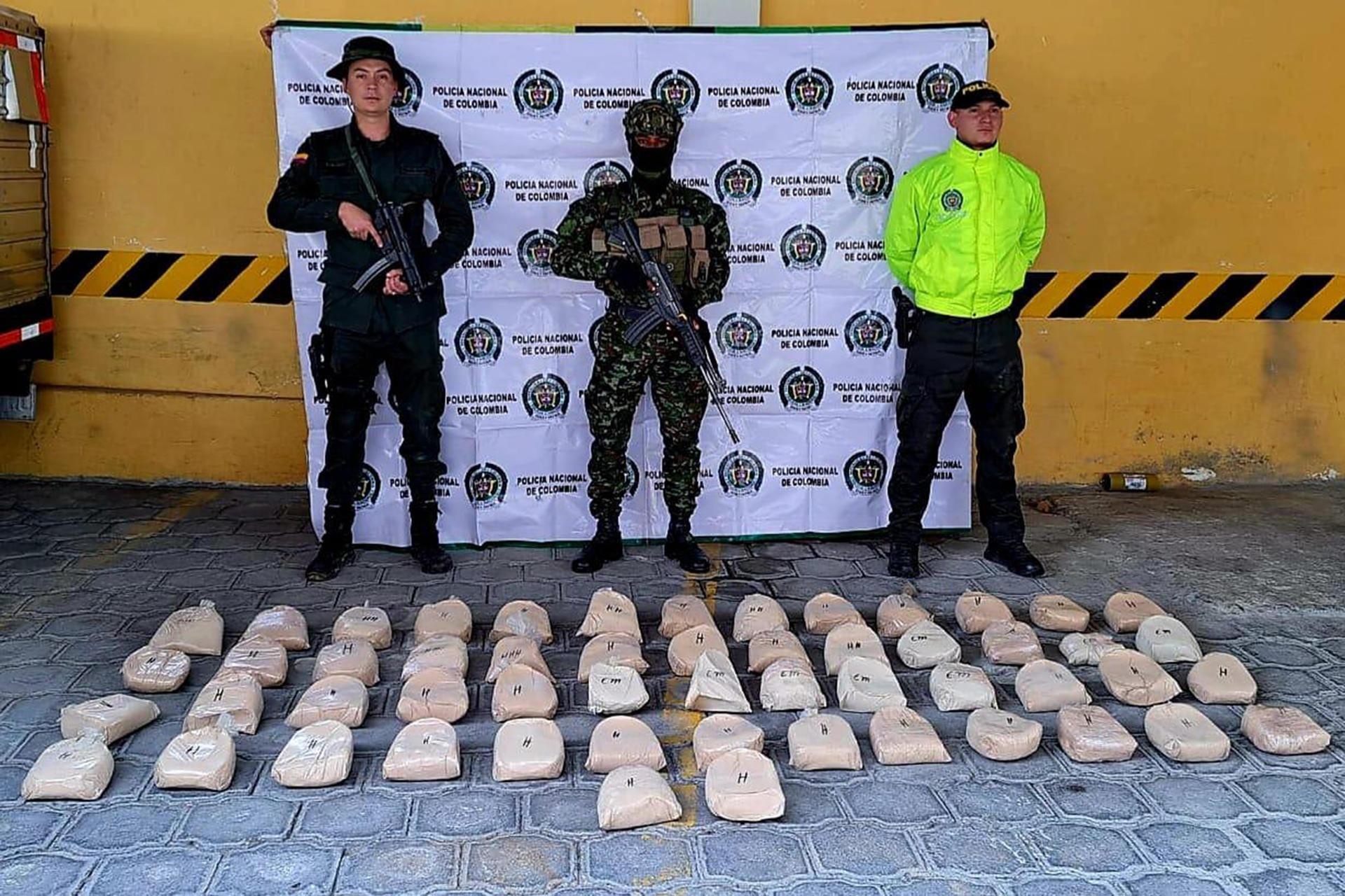 Fotografía cedida por la Policía de Colombia que muestra a uniformados mientras custodian 53,5 kilos de heroína incautada en Buesaco, Nariño. (Policía de Colombia)