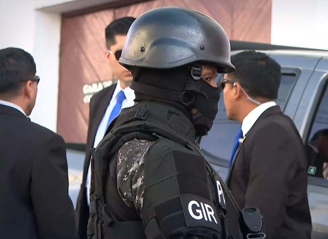 Imagen de un agente del GIR junto a policías de la Dirección Nacional de Seguridad y Protección de la Policía Nacional (Dinpro), resguardando a una autoridad. (Televistazo)